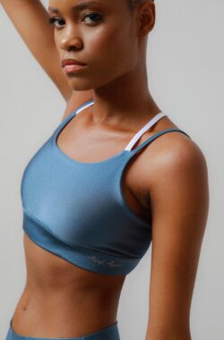 Athlefit Apparel – Alive dames sporttop in een diepe, licht iriserende hemelsblauwe kleur. Uitgerust met een witte band voor contrast en een elegante Y-vormige rug.