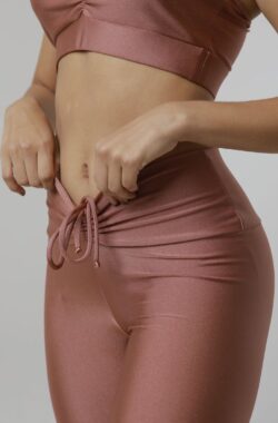 Athlefit Apparel – High-performance Healing damesleggings in neutraal roze met een strikje aan de voorkant en een naad aan de achterkant die je rondingen accentueert.